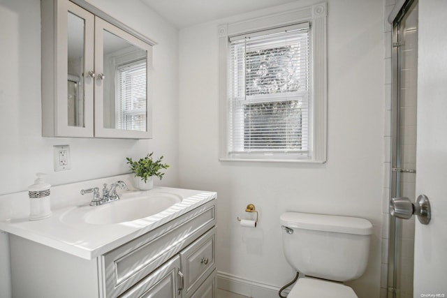 bathroom with plenty of natural light, toilet, and vanity