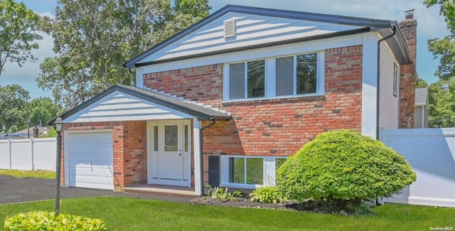 view of front of home with a garage and a front lawn