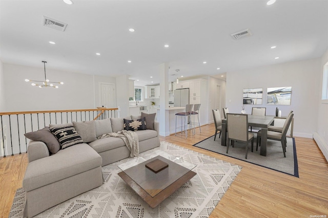 living room featuring a chandelier and light hardwood / wood-style flooring