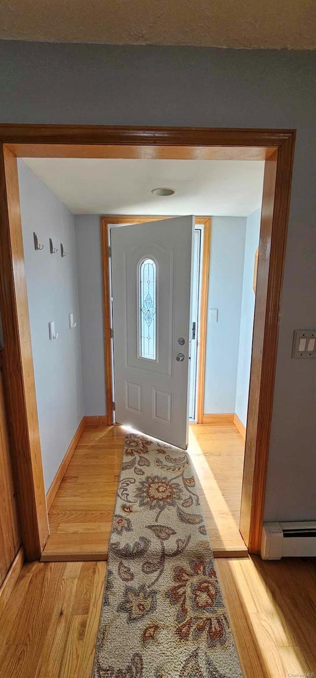 entrance foyer with light wood-type flooring and a baseboard heating unit