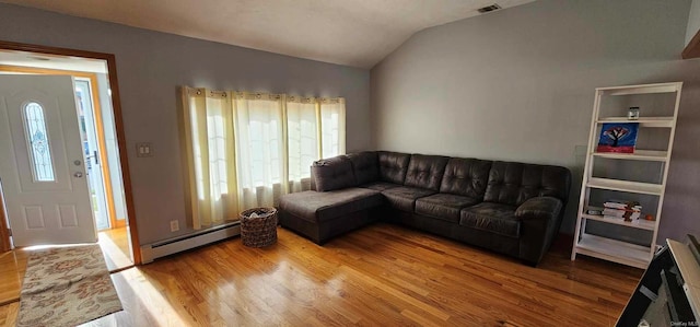 living room with vaulted ceiling, light hardwood / wood-style floors, and a baseboard heating unit