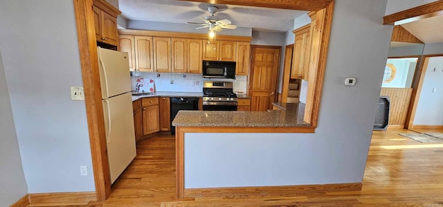 kitchen with ceiling fan, sink, kitchen peninsula, black appliances, and light wood-type flooring