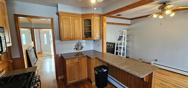 kitchen with decorative backsplash, ceiling fan, baseboard heating, light hardwood / wood-style floors, and kitchen peninsula