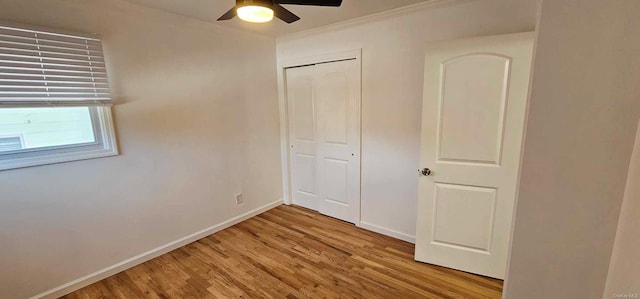 unfurnished bedroom featuring light wood-type flooring, a closet, ceiling fan, and ornamental molding