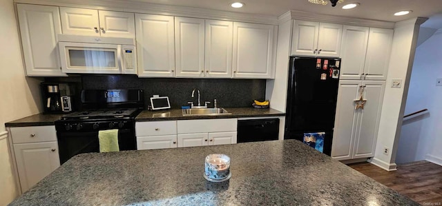 kitchen featuring backsplash, dark wood-type flooring, sink, black appliances, and white cabinetry