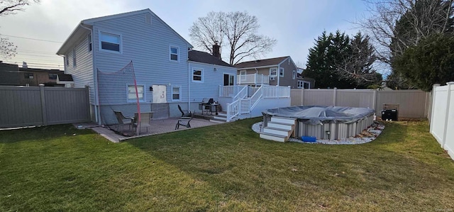 rear view of house with a lawn and a swimming pool side deck