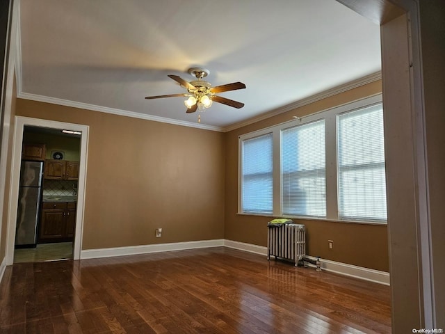 empty room featuring radiator, ceiling fan, crown molding, and dark hardwood / wood-style floors