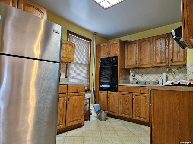 kitchen with decorative backsplash and stainless steel fridge