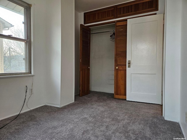 unfurnished bedroom featuring carpet flooring and a closet