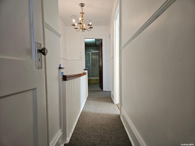 hallway featuring carpet flooring and a chandelier