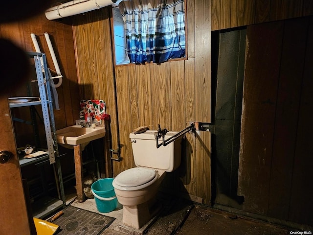 bathroom featuring toilet and wooden walls