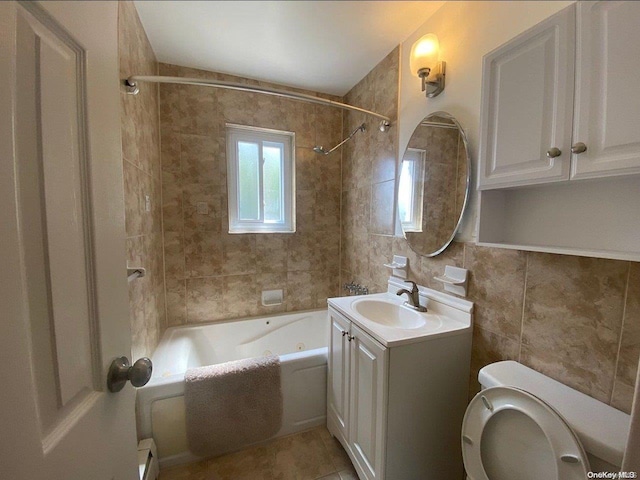 full bathroom with tile patterned flooring, tiled shower / bath combo, toilet, baseboard heating, and tile walls