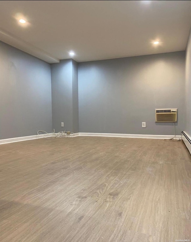 empty room featuring wood-type flooring and a wall unit AC