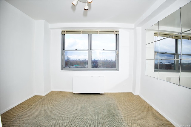 spare room with carpet floors and radiator heating unit