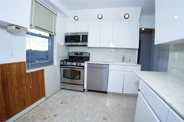 kitchen with decorative backsplash, appliances with stainless steel finishes, white cabinetry, and sink