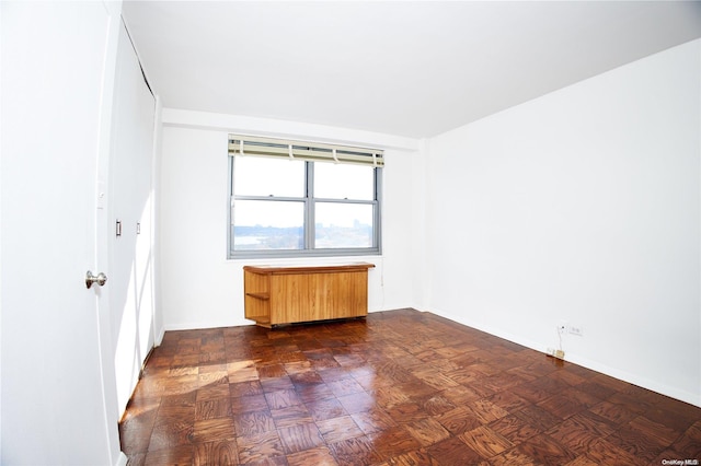 empty room with dark hardwood / wood-style flooring