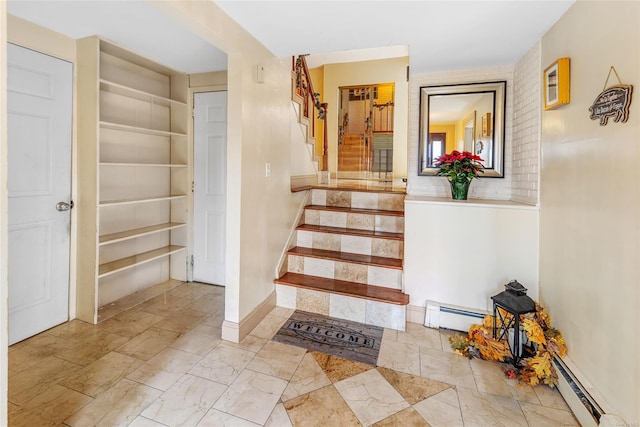 stairway featuring built in features and a baseboard radiator