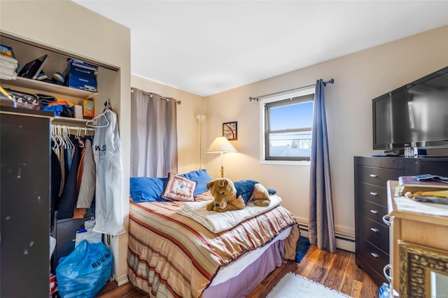 bedroom featuring dark wood-type flooring and a baseboard radiator