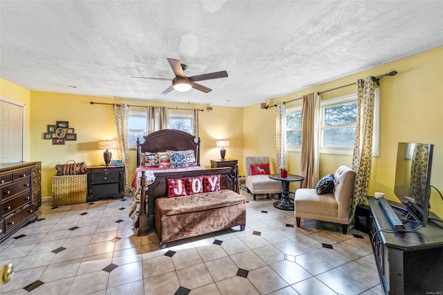 bedroom featuring a textured ceiling, ceiling fan, light tile patterned floors, and multiple windows