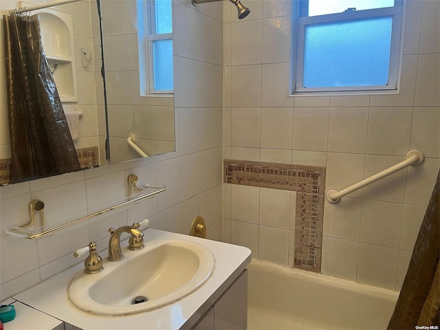 bathroom with backsplash, vanity, shower / bath combination with curtain, and tile walls