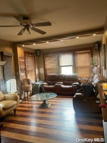 living room with ceiling fan and beamed ceiling