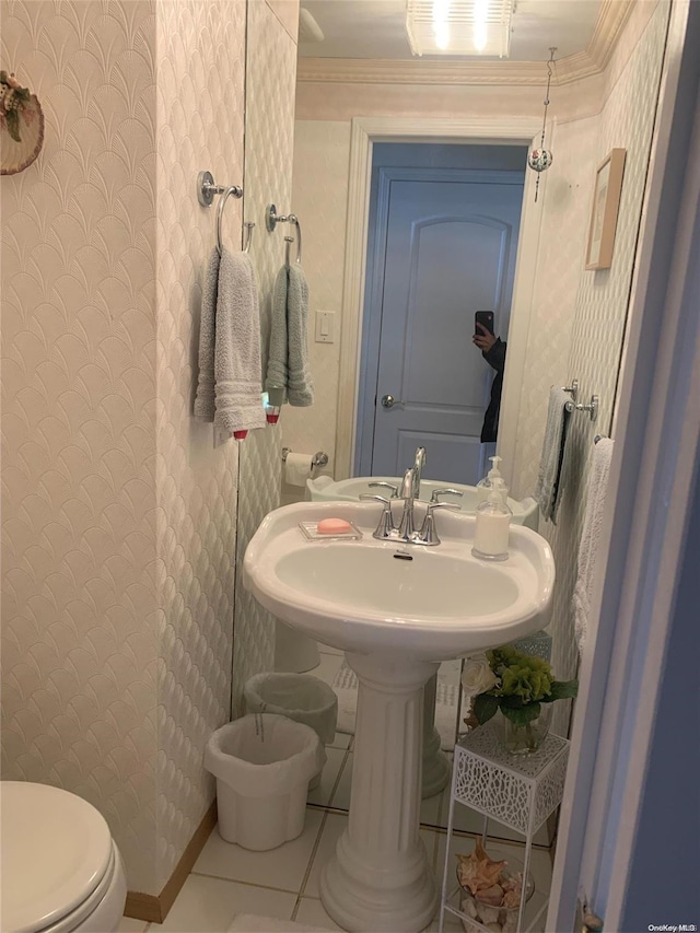 bathroom with tile patterned flooring, crown molding, and toilet