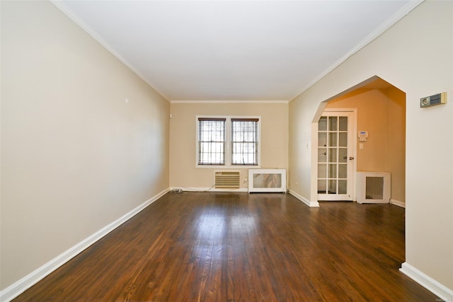 spare room with dark wood-type flooring, an AC wall unit, crown molding, and radiator heating unit