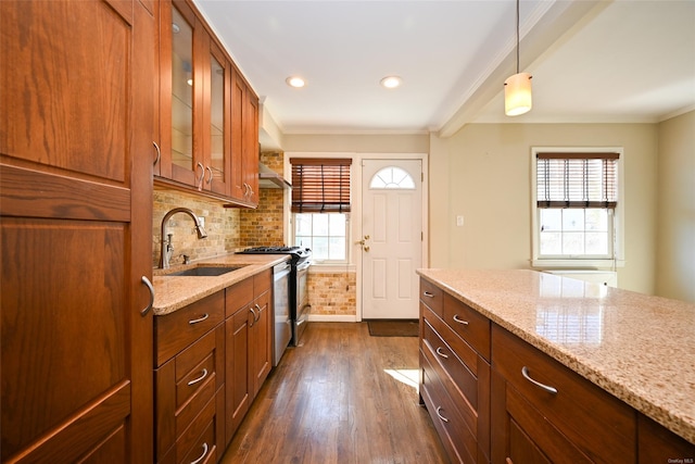 kitchen with sink, stainless steel range oven, light stone counters, and hanging light fixtures