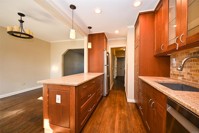 kitchen with light stone countertops, dark hardwood / wood-style floors, hanging light fixtures, stainless steel appliances, and sink