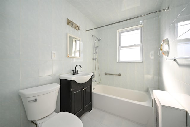 full bathroom featuring tiled shower / bath, tile walls, toilet, tile patterned floors, and vanity