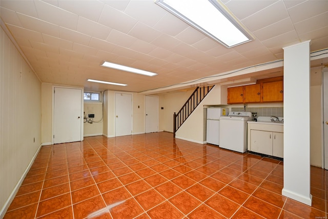 basement featuring washer / dryer and white refrigerator