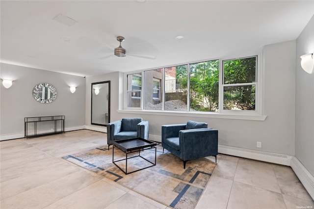 living area with ceiling fan, light tile patterned flooring, and a baseboard heating unit