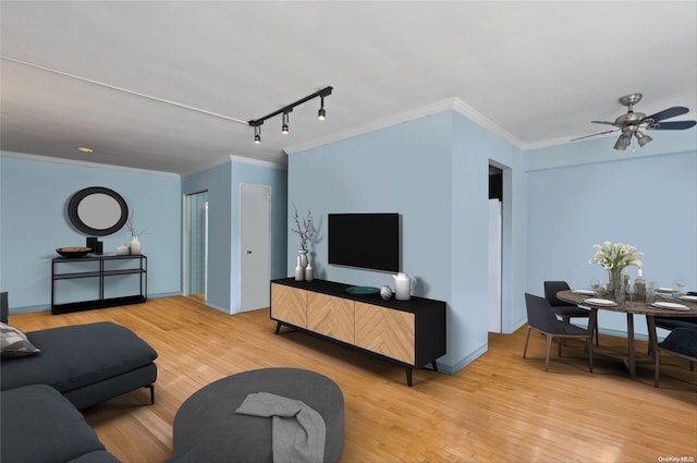 living room with track lighting, ceiling fan, crown molding, and light hardwood / wood-style flooring