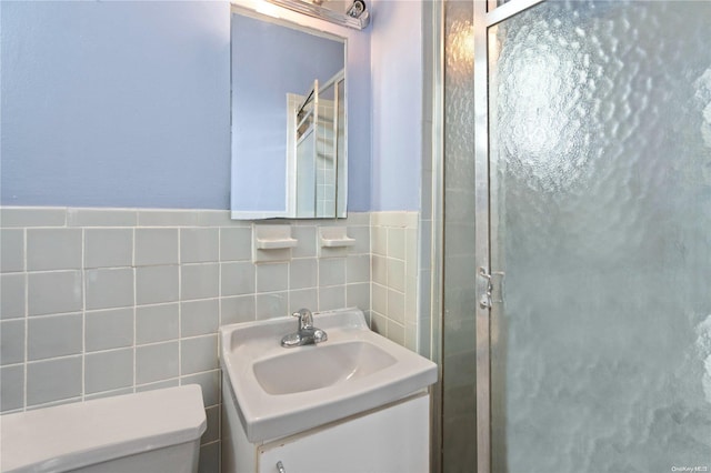 bathroom with walk in shower, vanity, tile walls, and toilet