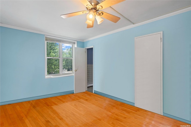 empty room with hardwood / wood-style flooring, ceiling fan, and crown molding