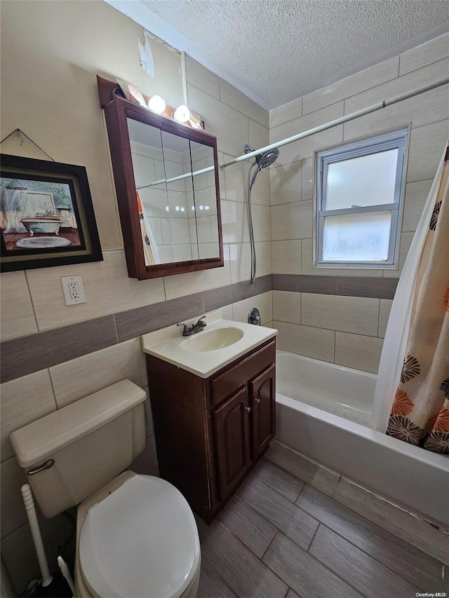 full bathroom with vanity, a textured ceiling, toilet, and shower / bath combo with shower curtain