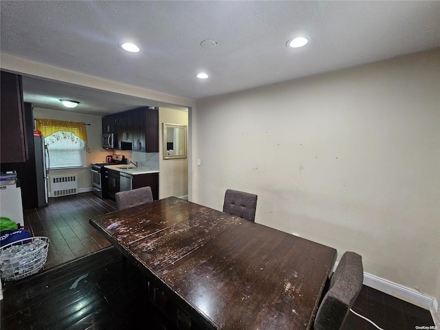 dining area with radiator heating unit and dark wood-type flooring