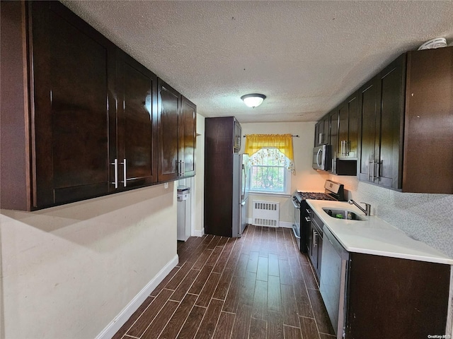 kitchen featuring sink, dark hardwood / wood-style floors, a textured ceiling, dark brown cabinetry, and stainless steel appliances