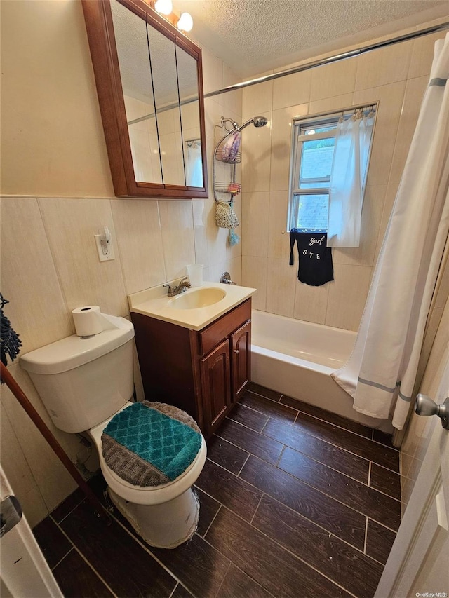 full bathroom with vanity, toilet, shower / bath combo with shower curtain, and a textured ceiling