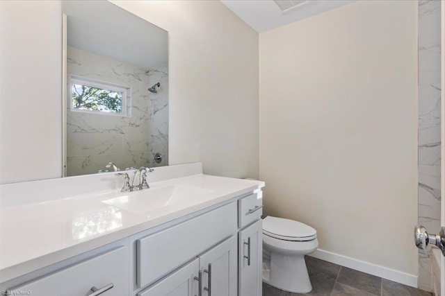 bathroom featuring vanity, toilet, and tiled shower