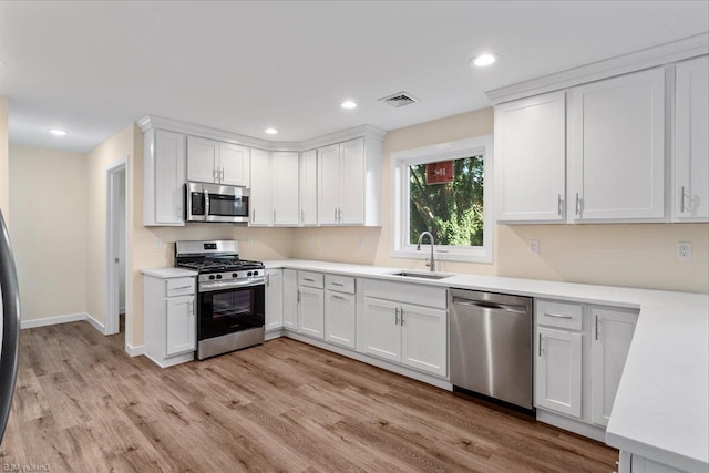 kitchen with light hardwood / wood-style flooring, stainless steel appliances, white cabinetry, and sink