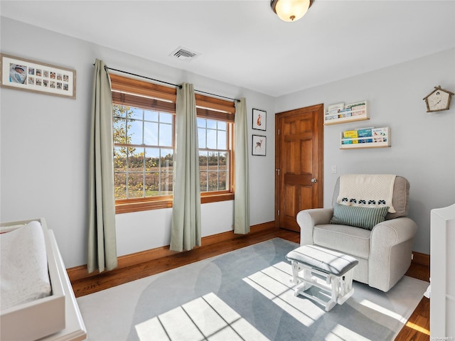 sitting room featuring baseboards, visible vents, and wood finished floors