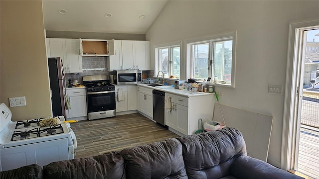 88 Bayview Ave, Lindenhurst, NY 11757 - kitchen with stainless steel appliances, tasteful backsplash, plenty of natural light, wood finished floors, and lofted ceiling
