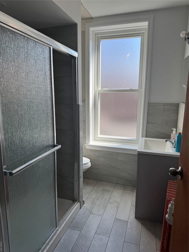 776 Hewitt, Bronx, NY 10455 - bathroom featuring vanity, a shower stall, toilet, and tile walls