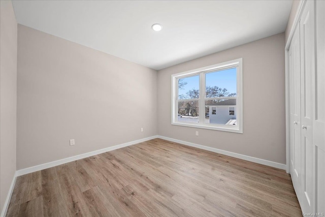 unfurnished bedroom with light hardwood / wood-style flooring and a closet