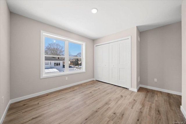 unfurnished bedroom with light hardwood / wood-style floors and a closet