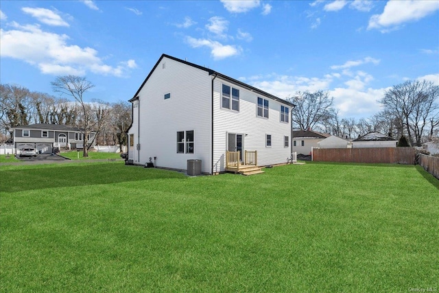 back of property with a lawn and central air condition unit