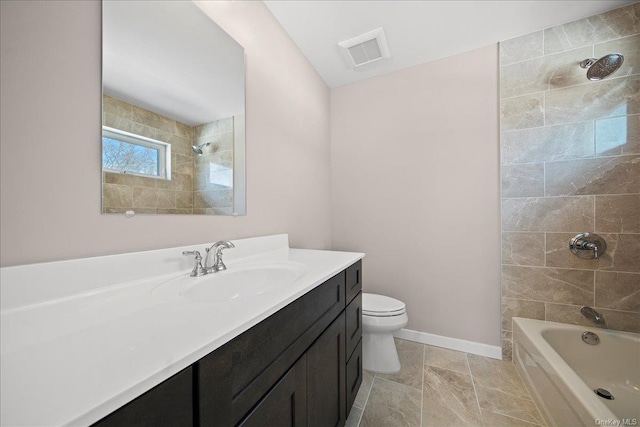 full bathroom featuring vanity, tiled shower / bath, and toilet