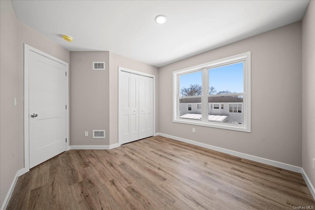 unfurnished bedroom featuring light hardwood / wood-style flooring and a closet