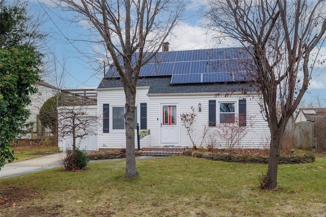 new england style home with solar panels and a front yard